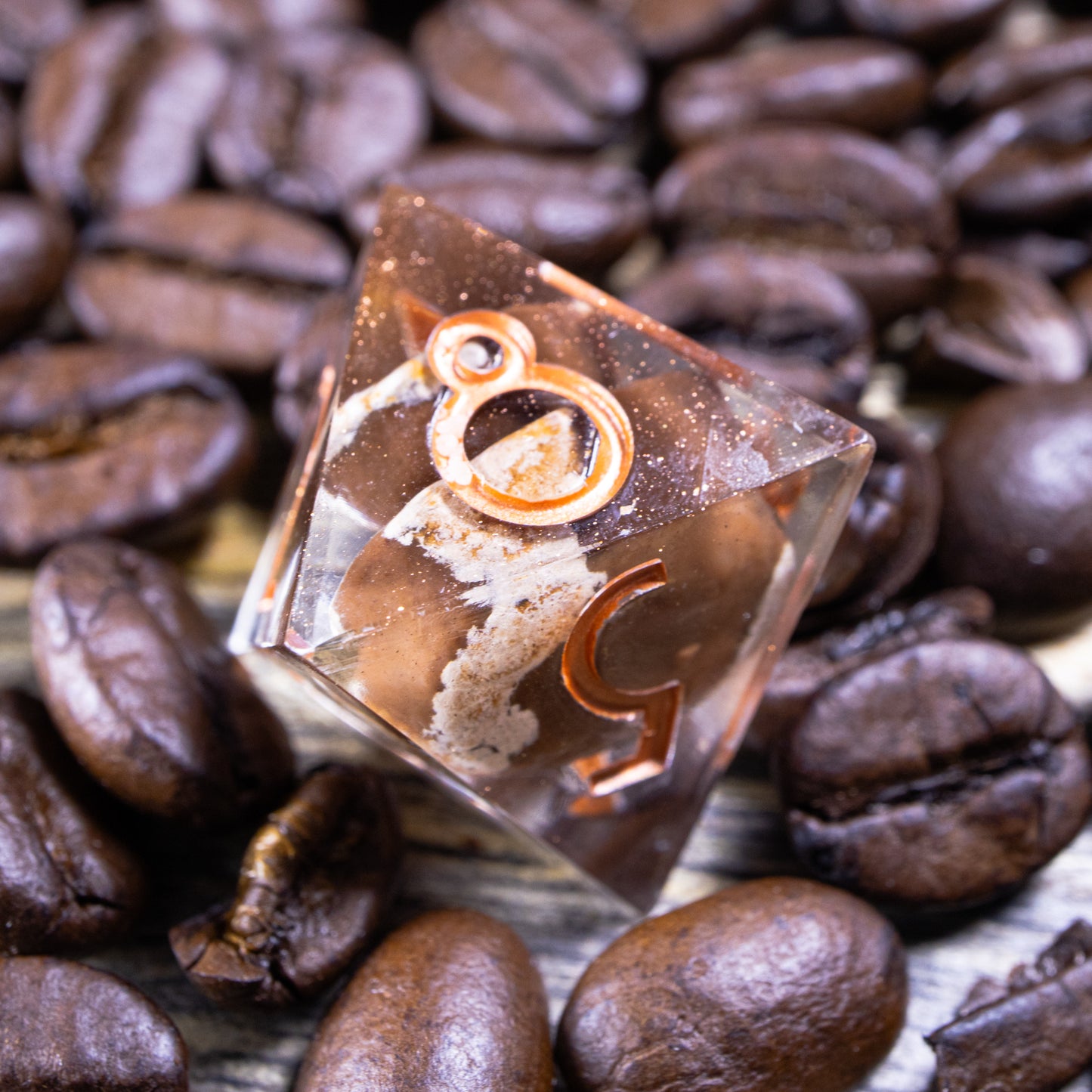 An eight-sided die, nestled gently on a pile of decorative coffee beans.