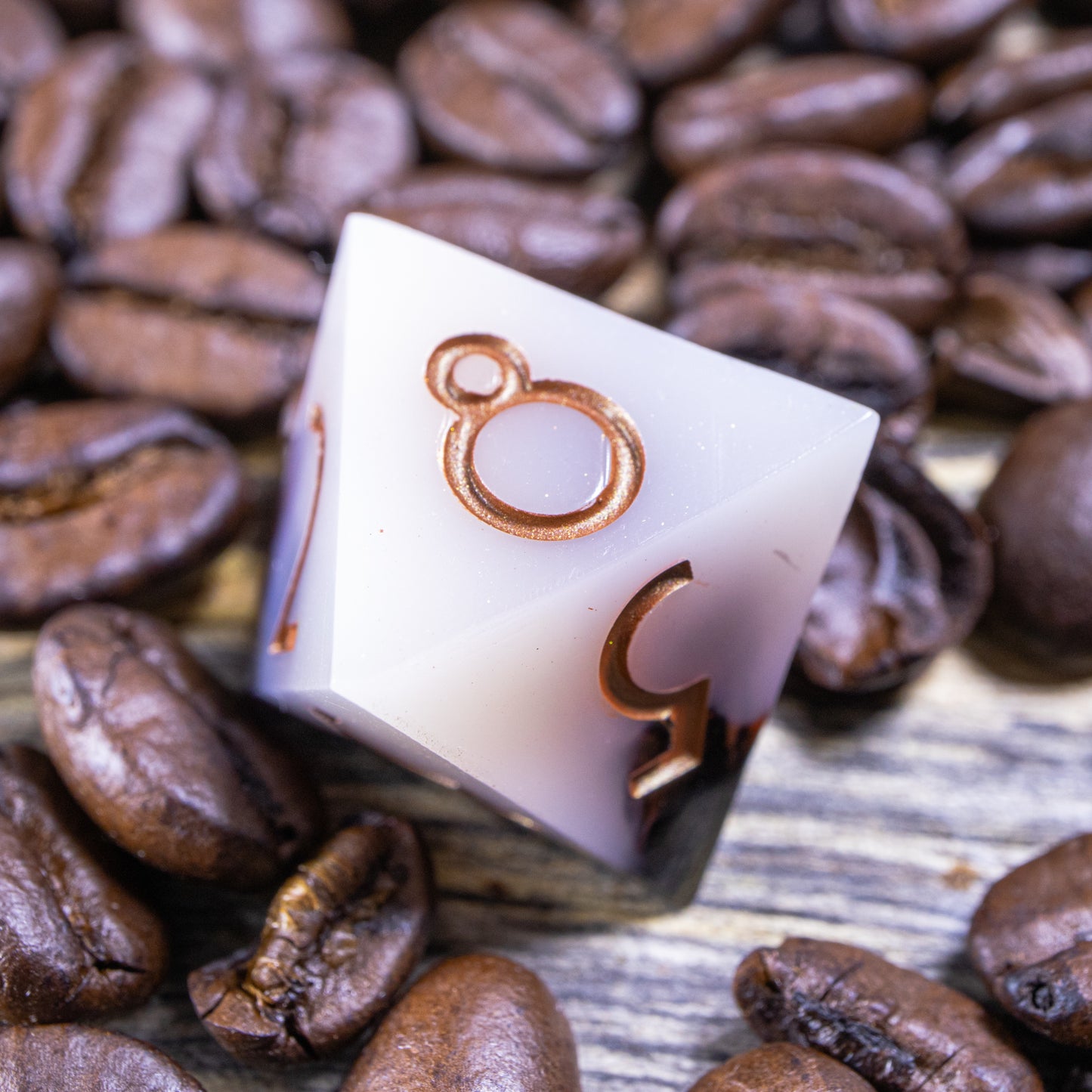 An eight-sided die, nestled gently on a pile of decorative coffee beans.