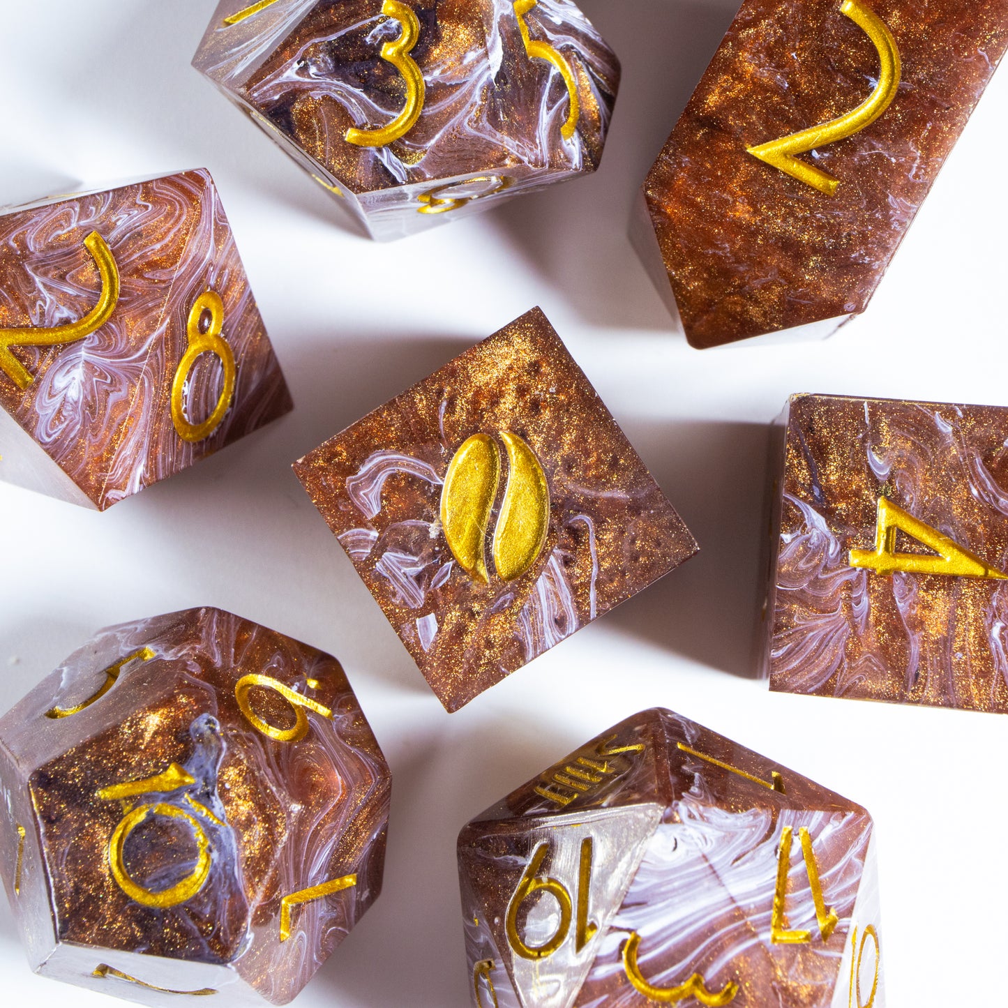 A bird’s-eye view of seven coffee themed dice, encircling an illustrated six-sided die in the center.