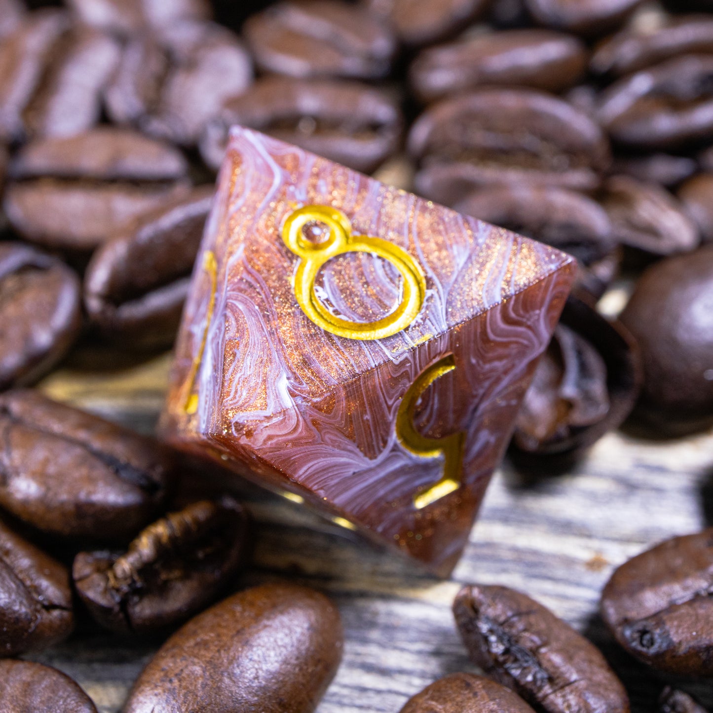 An eight-sided die, nestled gently on a pile of decorative coffee beans.