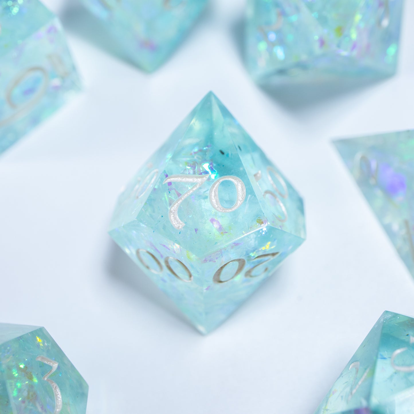 A close-up of a ten sided die at the heart of its kin, the rest of the dice set arranged in a circle around it.