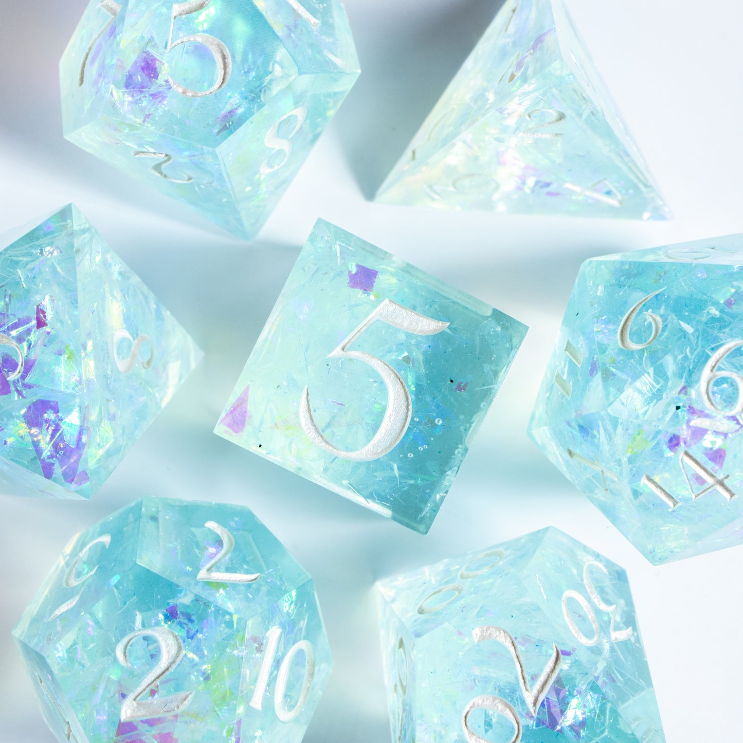 A bird’s-eye view of the complete set of blaring neon-pink seven polyhedral dice, encircling a six-sided die in the center.