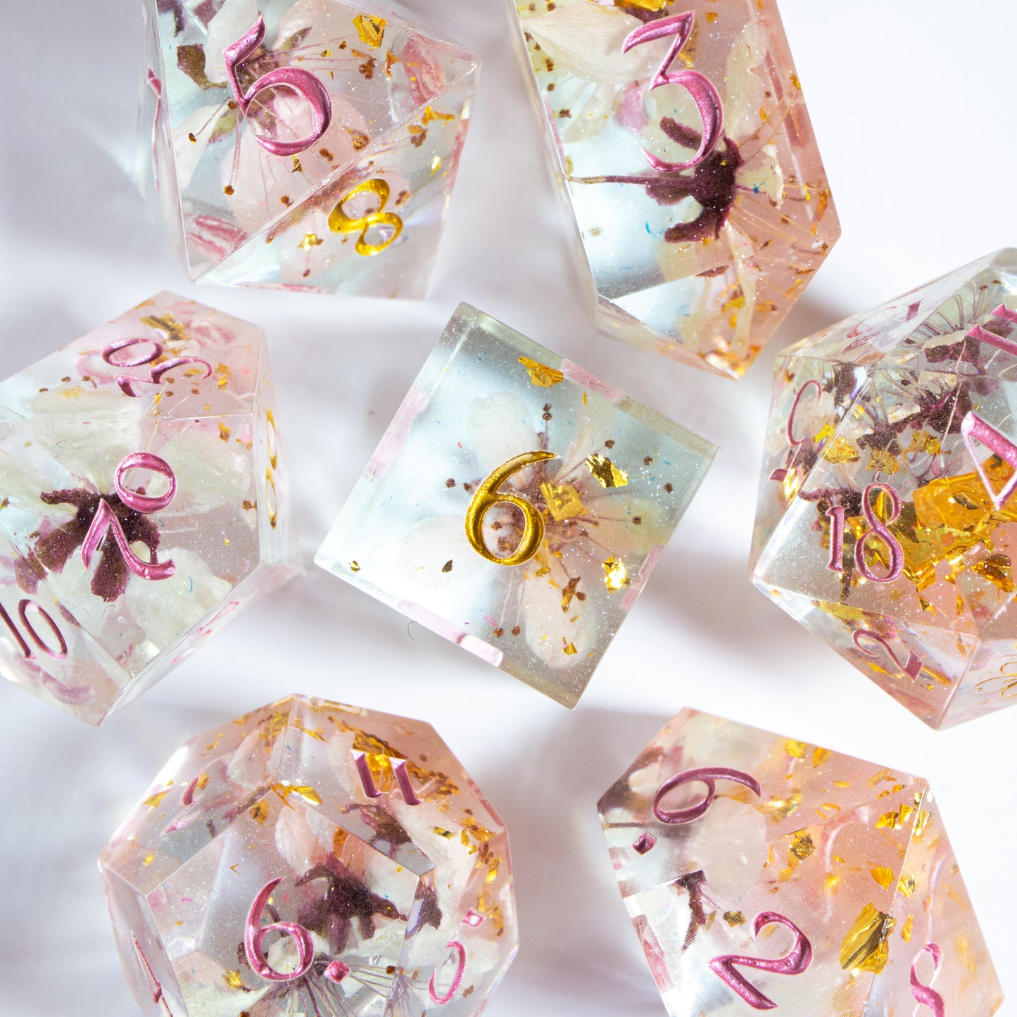 A bird’s-eye view of the complete set of seven polyhedral dice, encircling a six-sided die in the center.