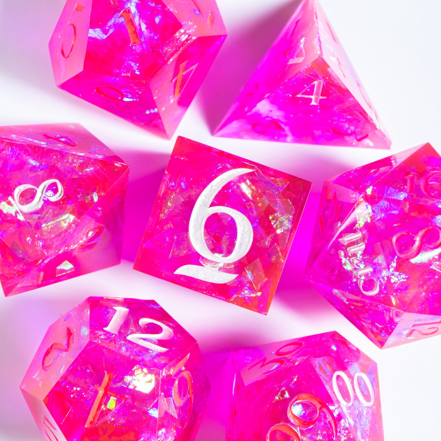 A bird’s-eye view of the complete set of blaring neon-pink seven polyhedral dice, encircling a six-sided die in the center.