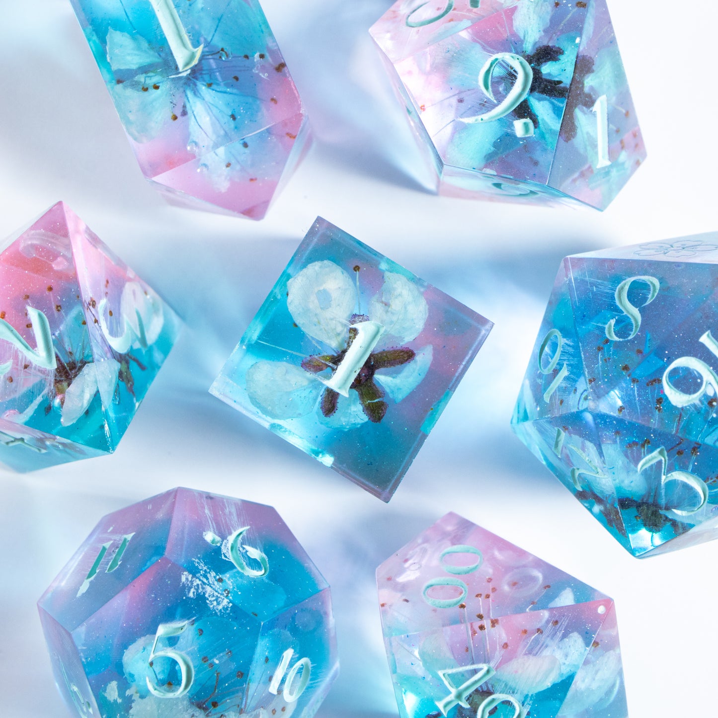 A bird’s-eye view of the complete set of seven polyhedral dice, encircling a six-sided die in the center.
