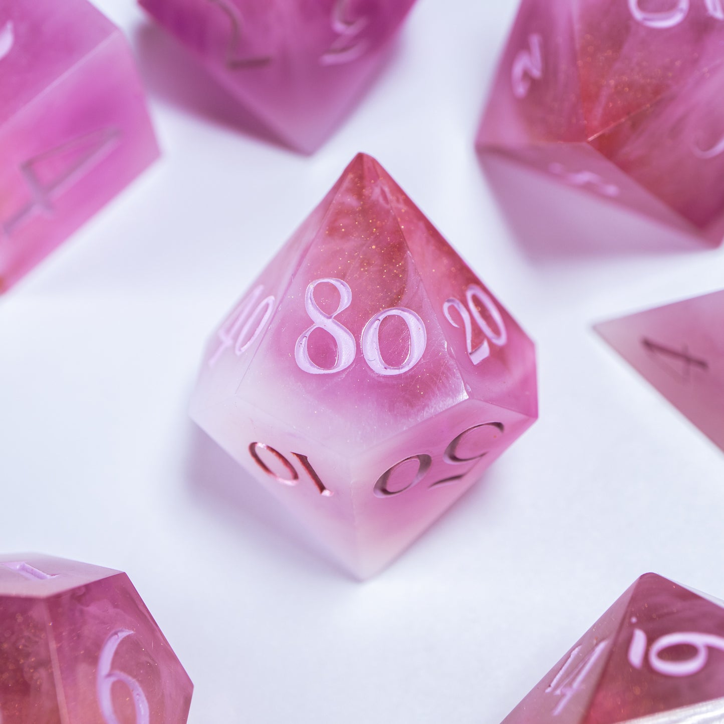 A close-up of a ten sided die at the heart of its kin, the rest of the dice set arranged in a circle around it.