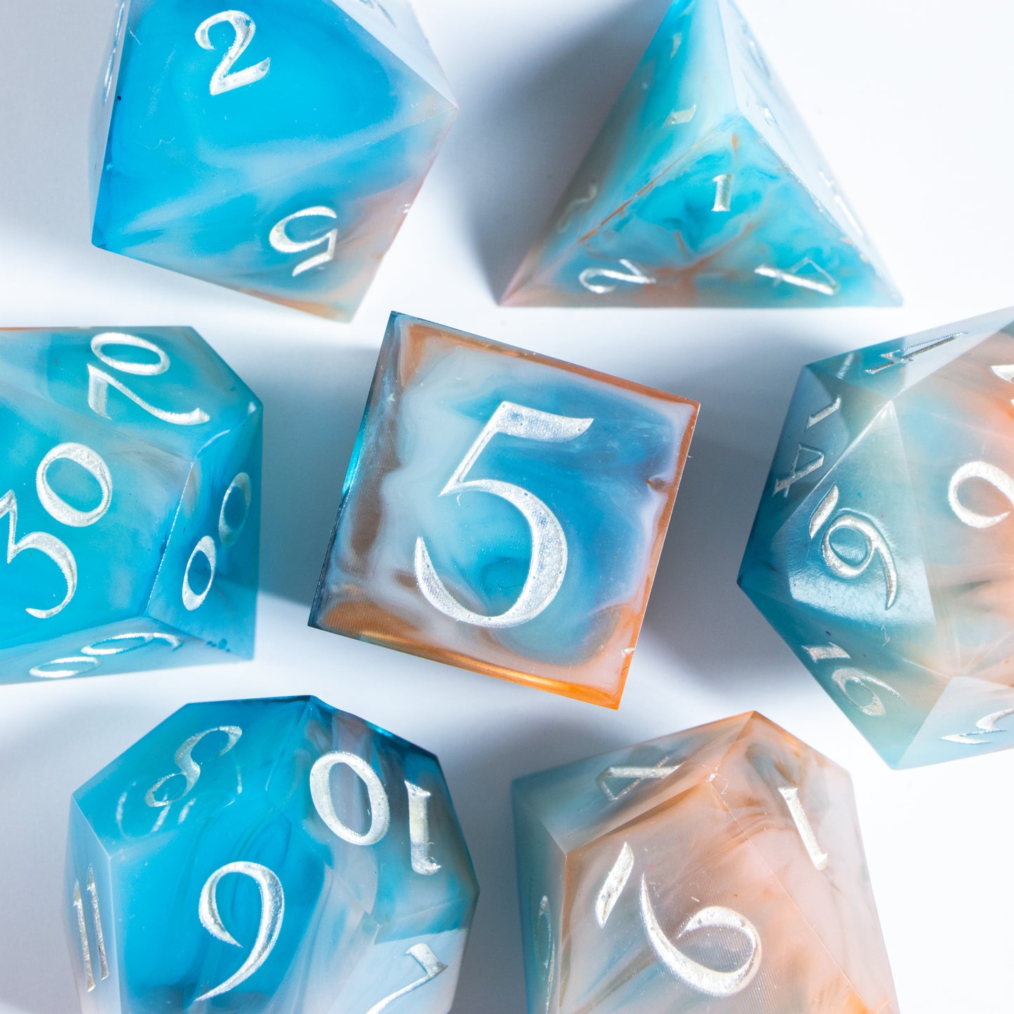 A bird’s-eye view of the complete set of seven polyhedral dice, encircling a six-sided die in the center.