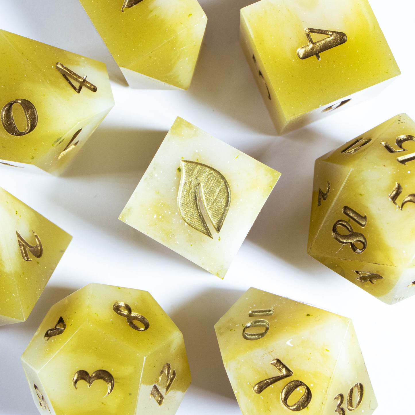A bird’s-eye view of seven tea themed dice, encircling an illustrated six-sided die in the center.
